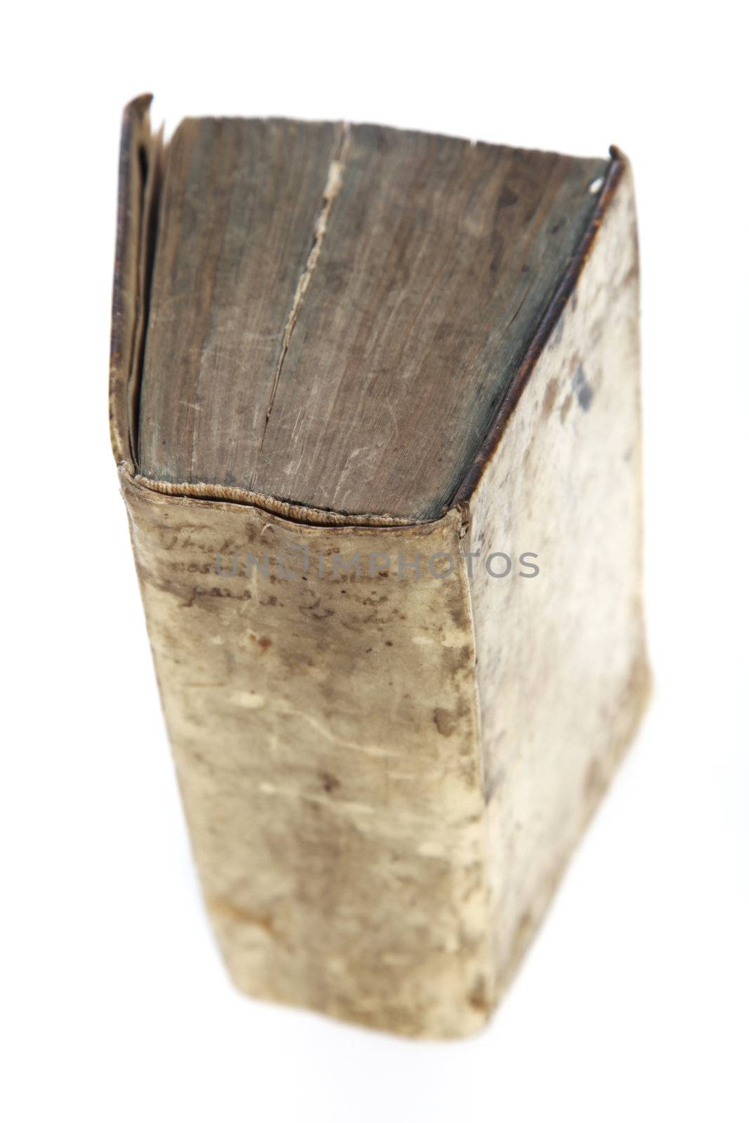 High angle view of an old worn vintage hardcover book with a stained distressed cover and pages with shallow dof on a white background