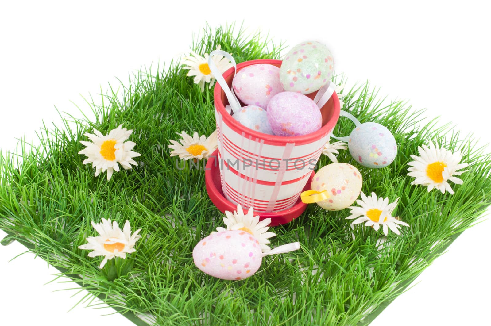 Easter eggs on the green grass and flowerpot isolated on white