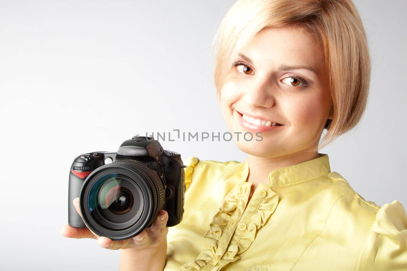 Young and beautiful girl with a professional camera in hand