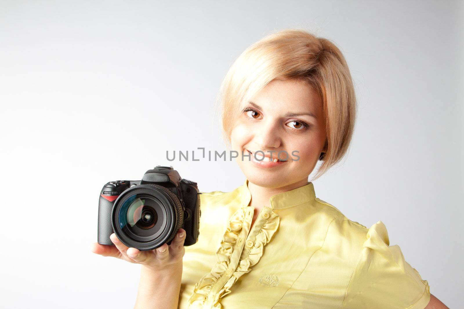 Young and beautiful girl with a professional camera in hand