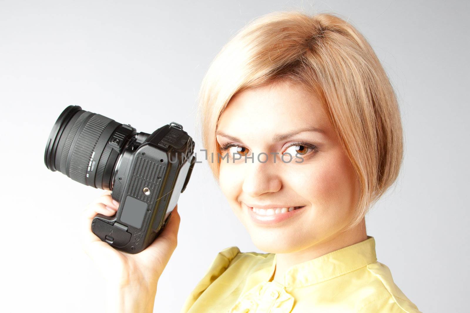 Young and beautiful girl with a professional camera in hand