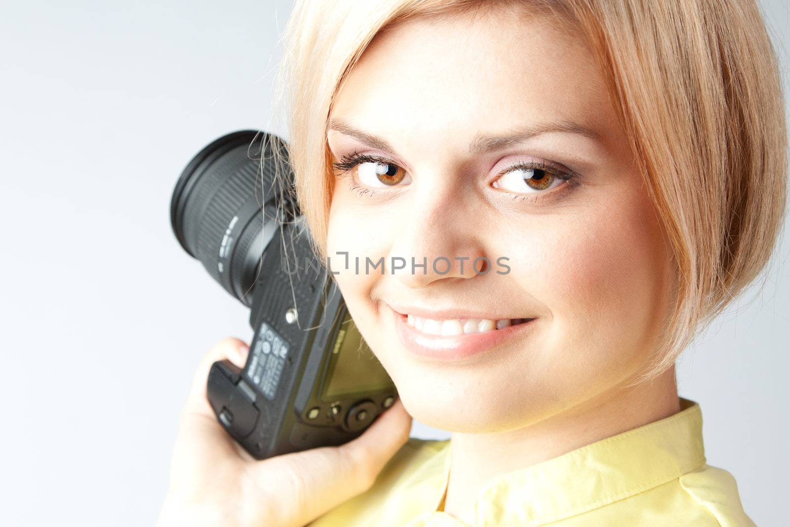 Young and beautiful girl with a professional camera in hand