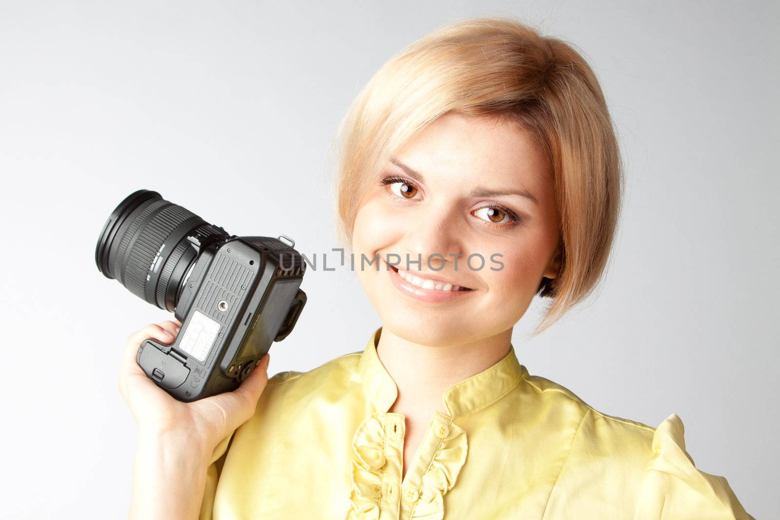 Young and beautiful girl with a professional camera in hand