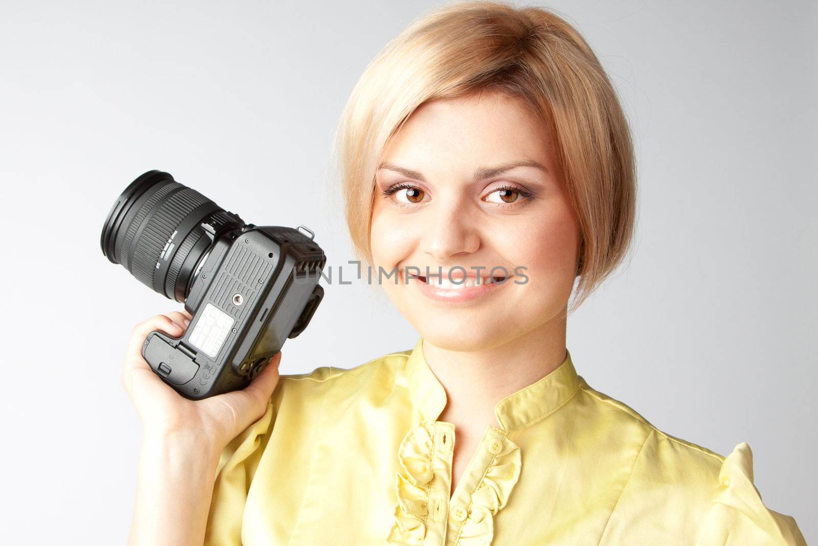 Young and beautiful girl with a professional camera in hand