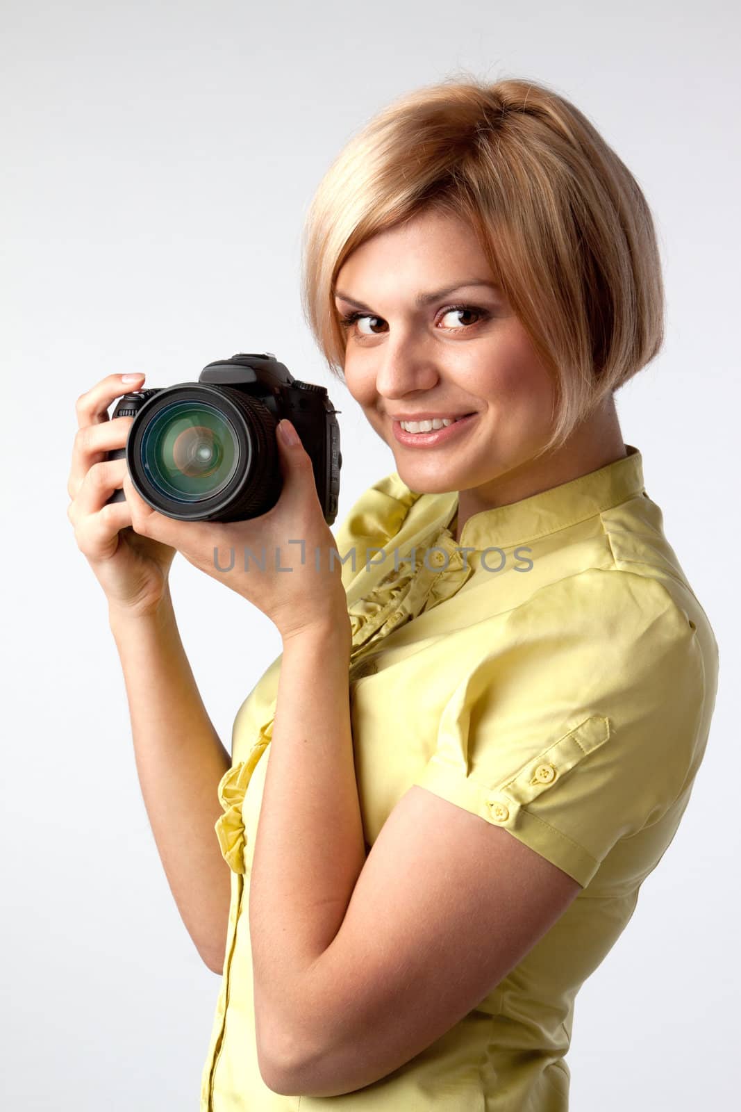 Young and beautiful girl with a professional camera in hand