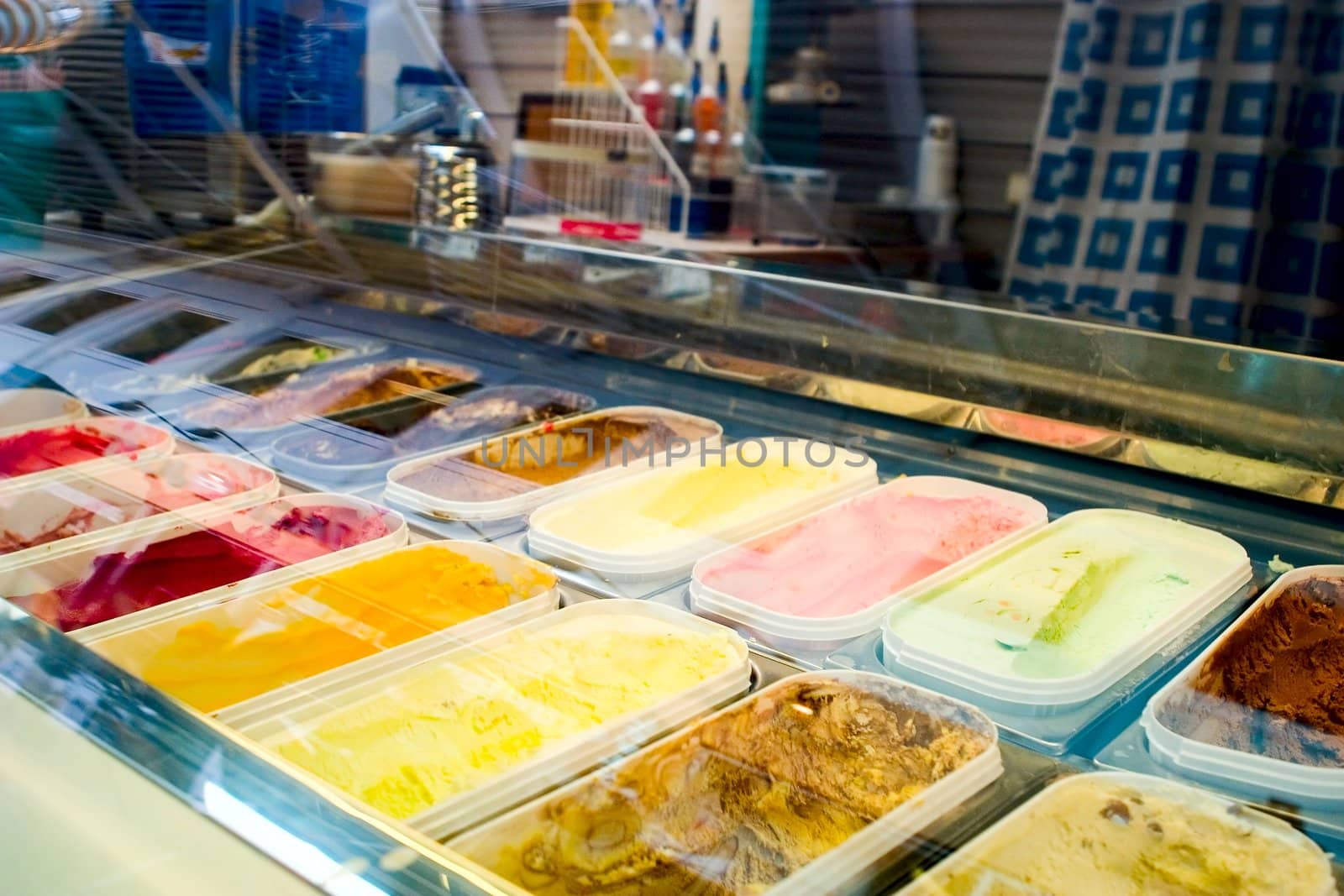 Rows of ice cream behind glass with reflection