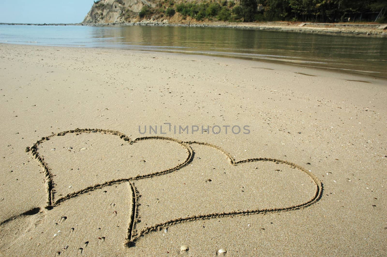 Two hearts drawn on a wet sandy beach