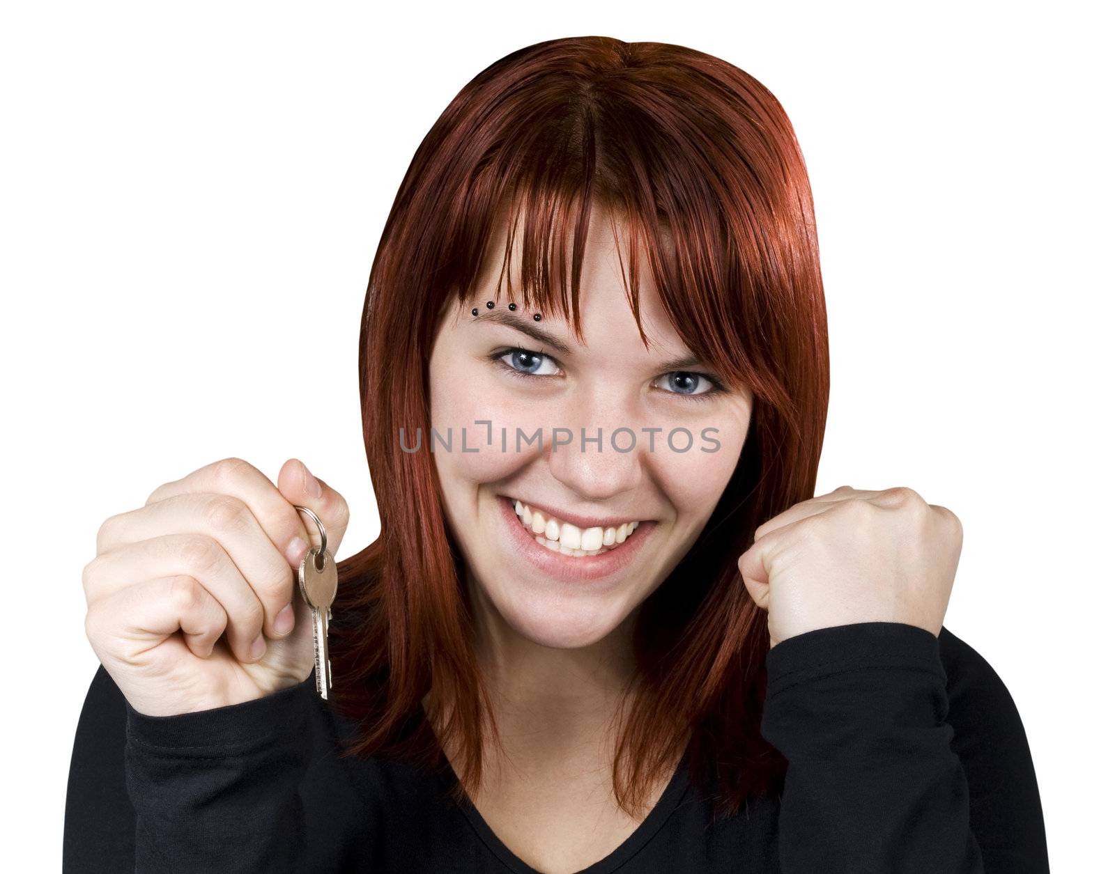 Studio shot of a cute redhead girl holding home or car keys and smiling her success out.