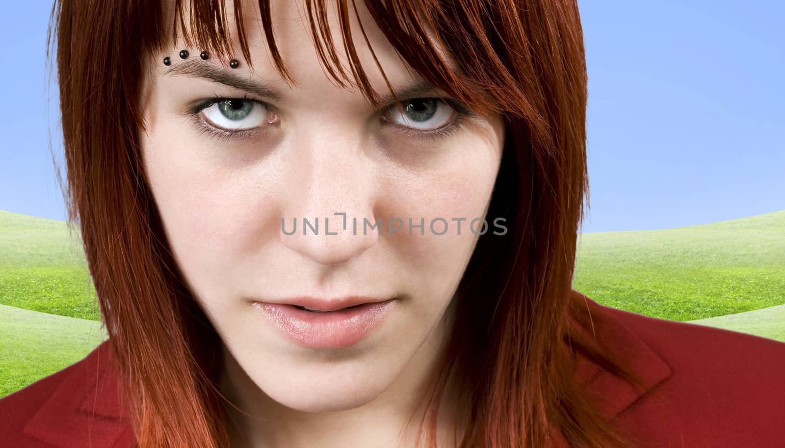 Cute redhead girl aggressively staring at the camera.

Studio shot.