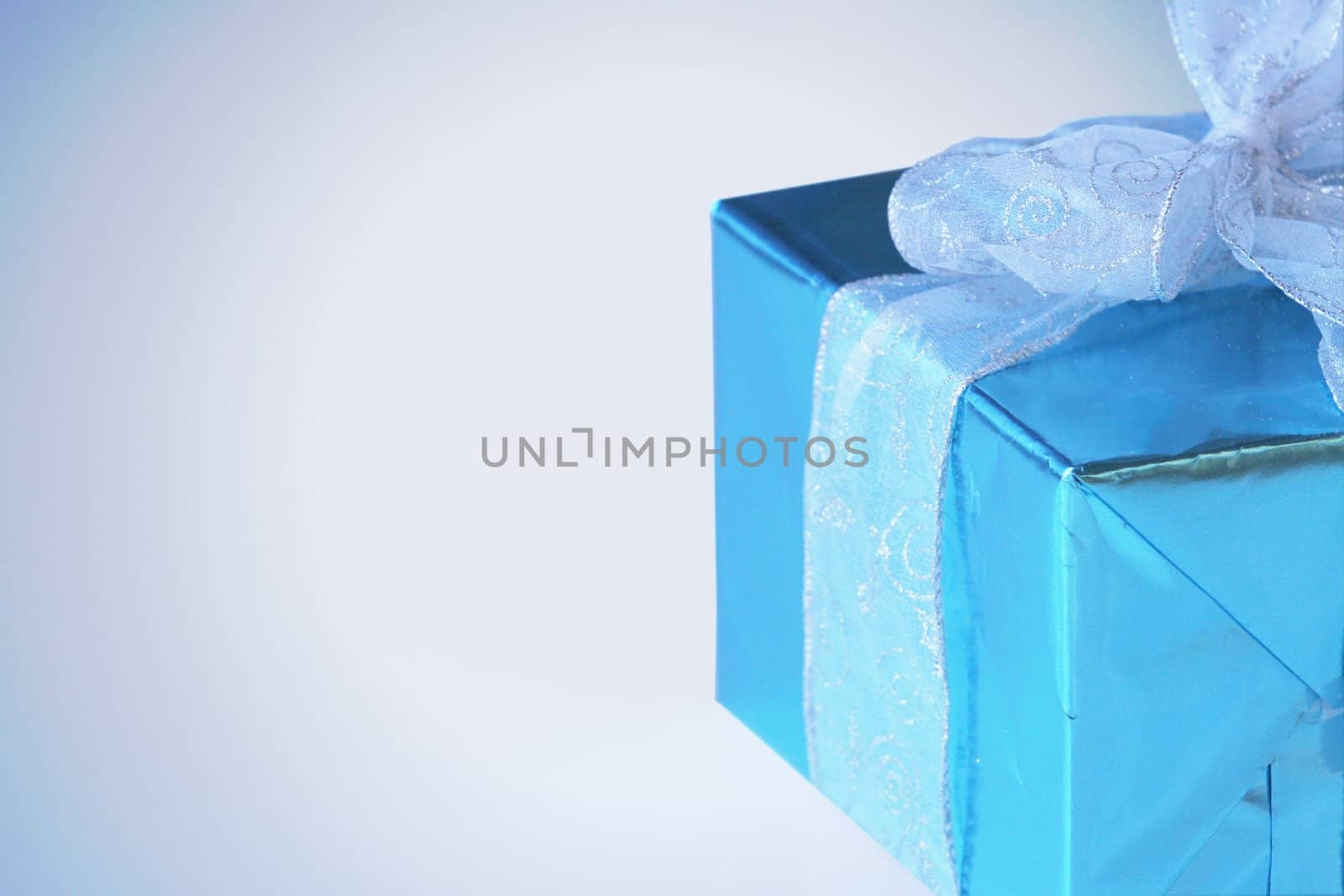 Elegant sky blue colored present with silver ribbons and bow isolated on white.