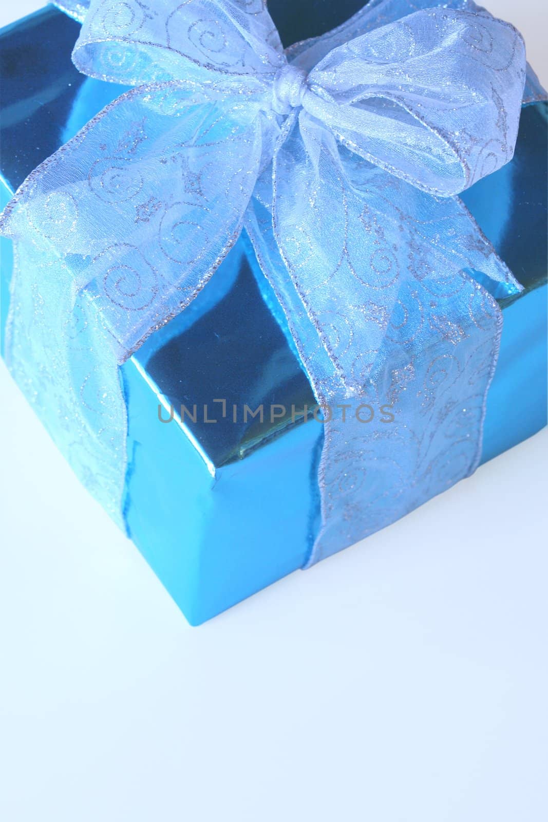 Elegant sky blue colored present with silver ribbons and bow isolated on white.