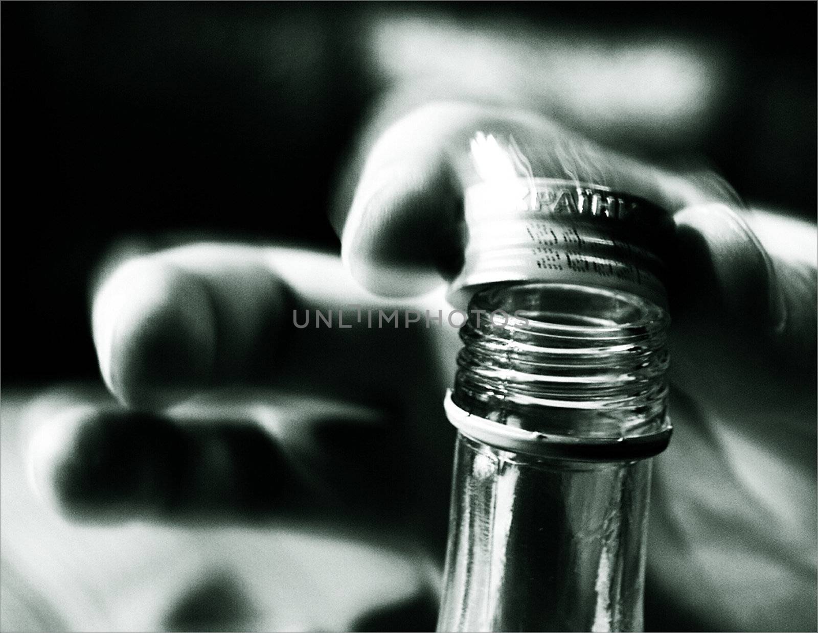 The image of a hand opening a bottle