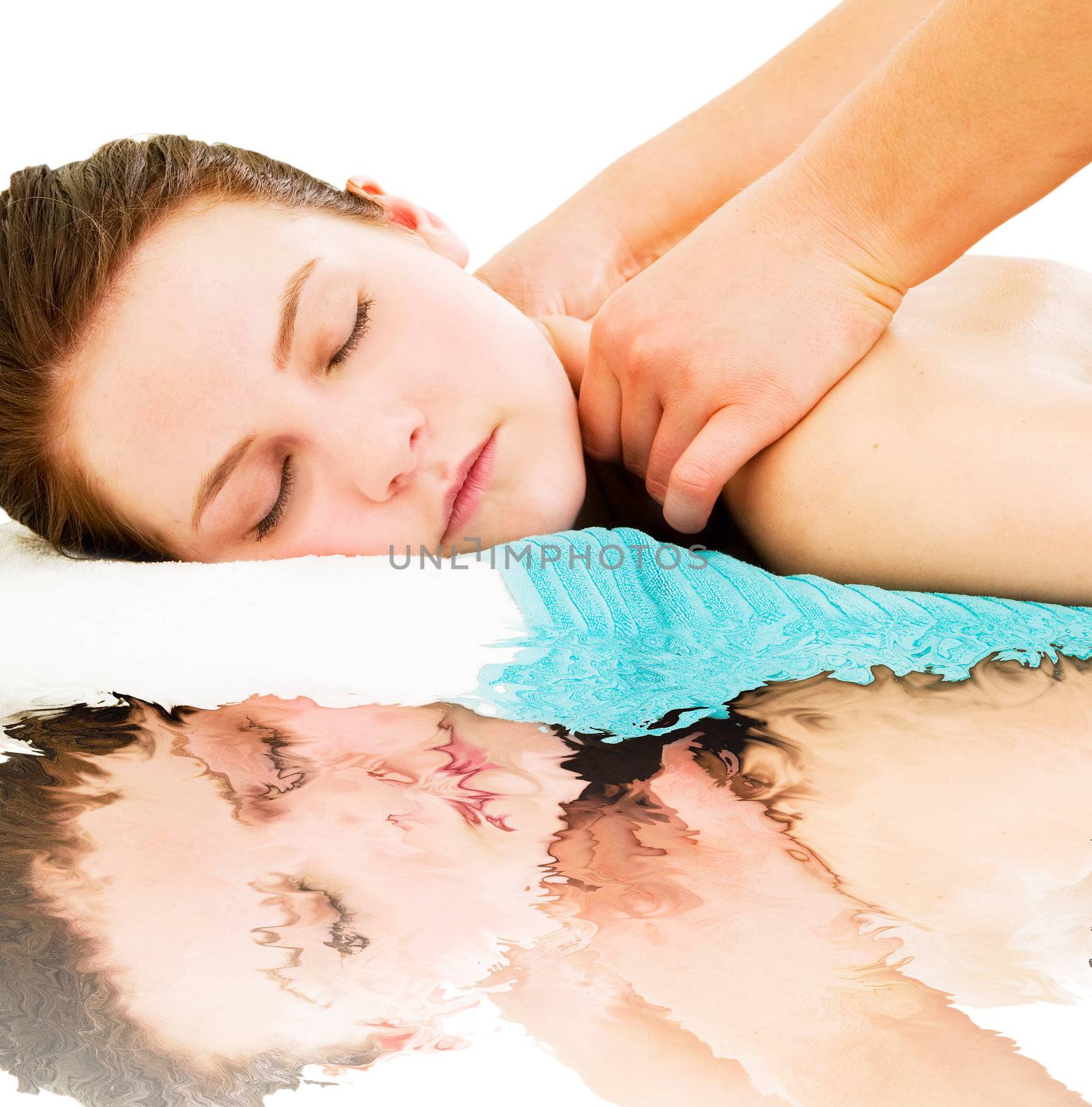 A young woman receiving a massage with her reflection in water