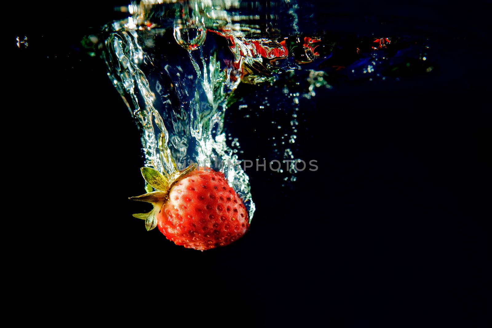 A strawberry splashing in water