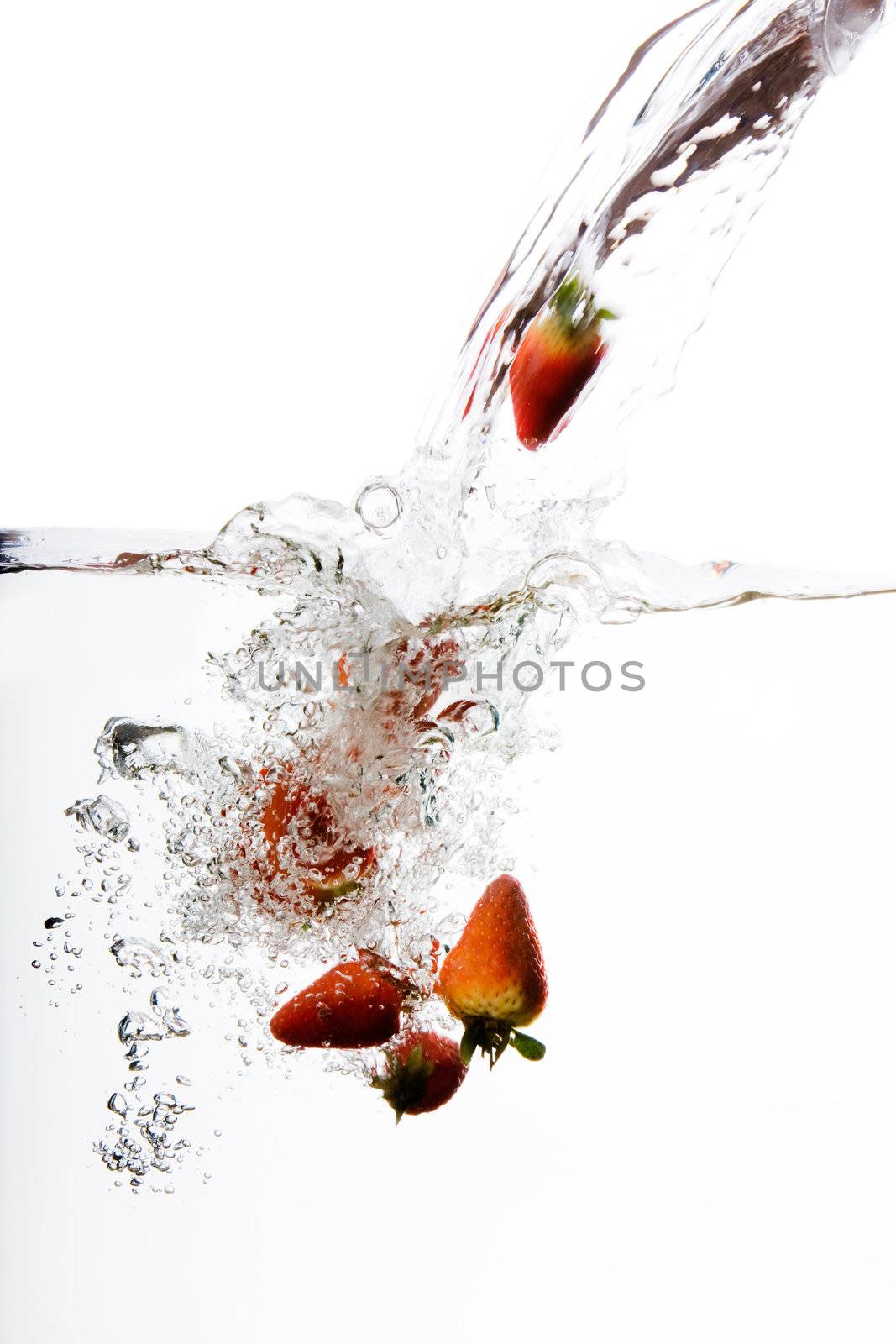 Fresh strawberries being poured in water