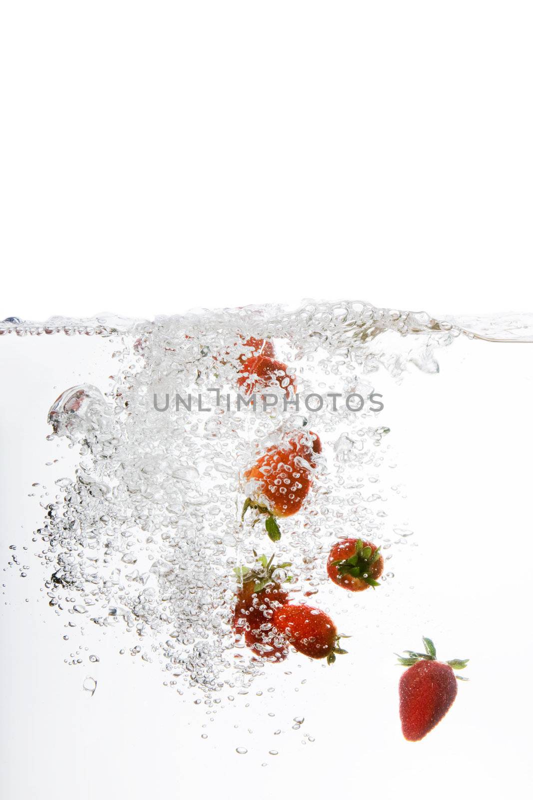 Fresh strawberries being poured in water