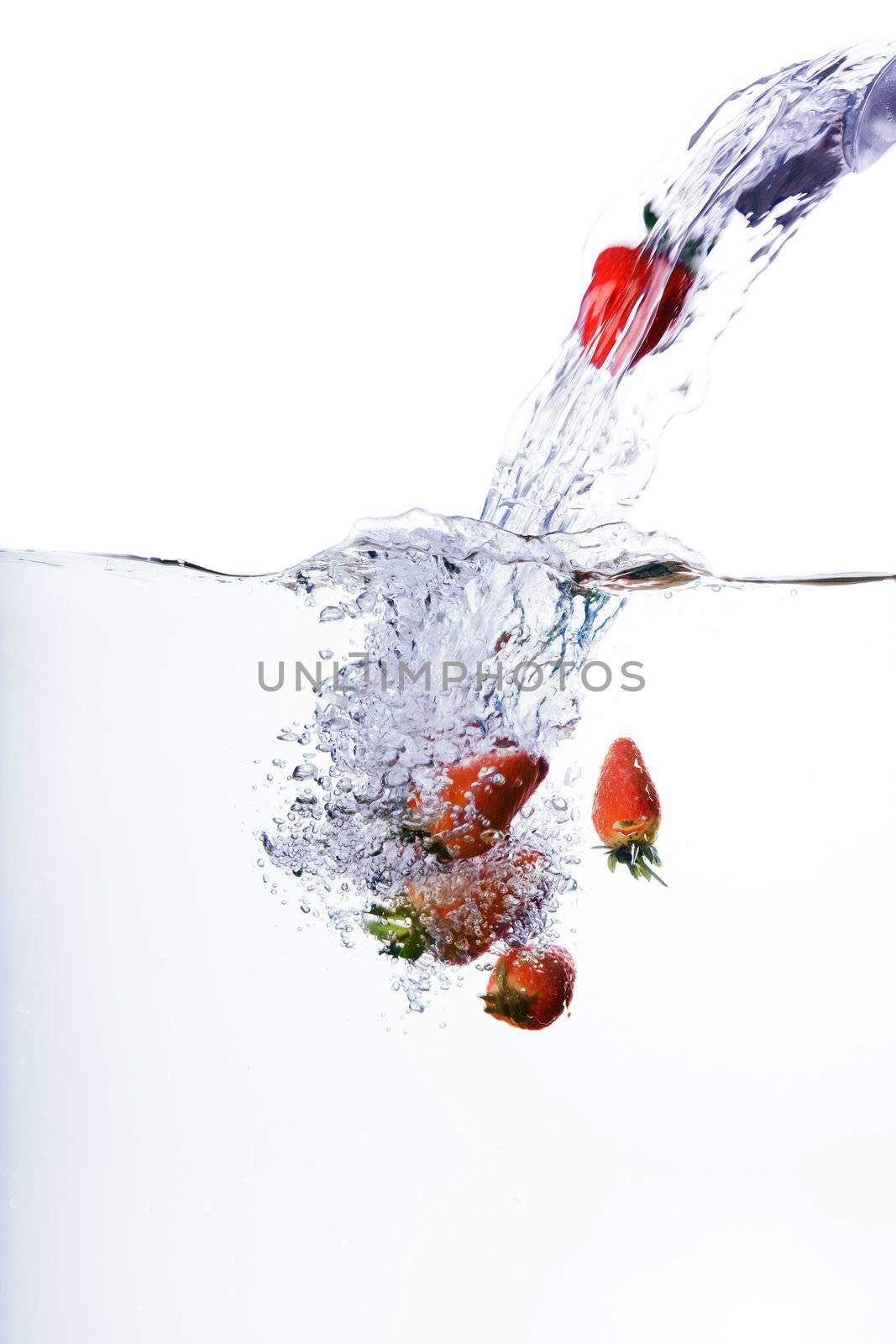 Fresh strawberries being poured in water