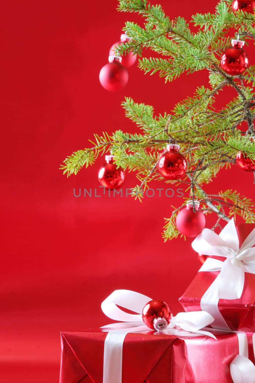 Elegant red presents under Christmas tree with deep rich red background.