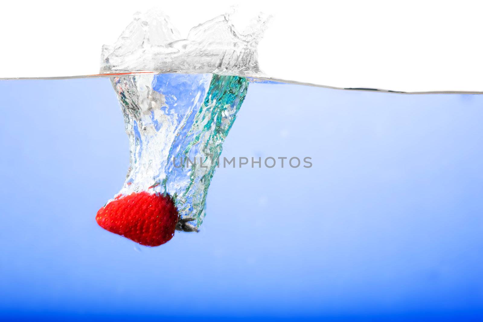 Fresh strawberries being poured in water