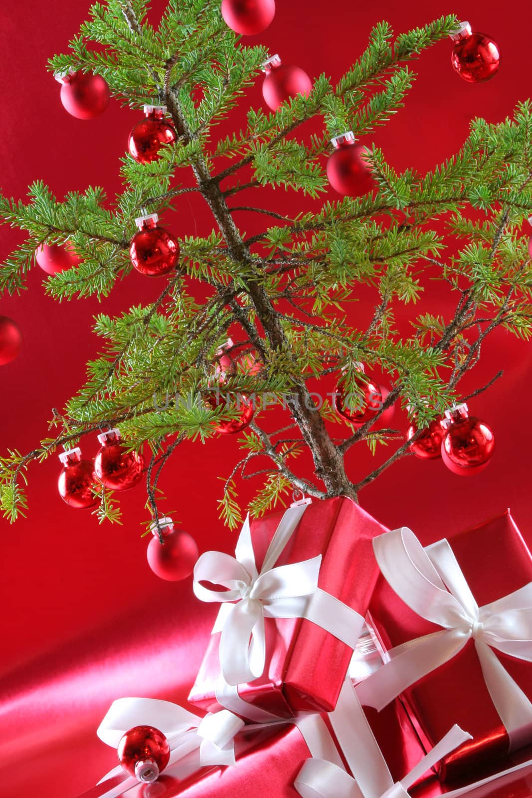 Elegant red presents under Christmas tree with deep rich red background.