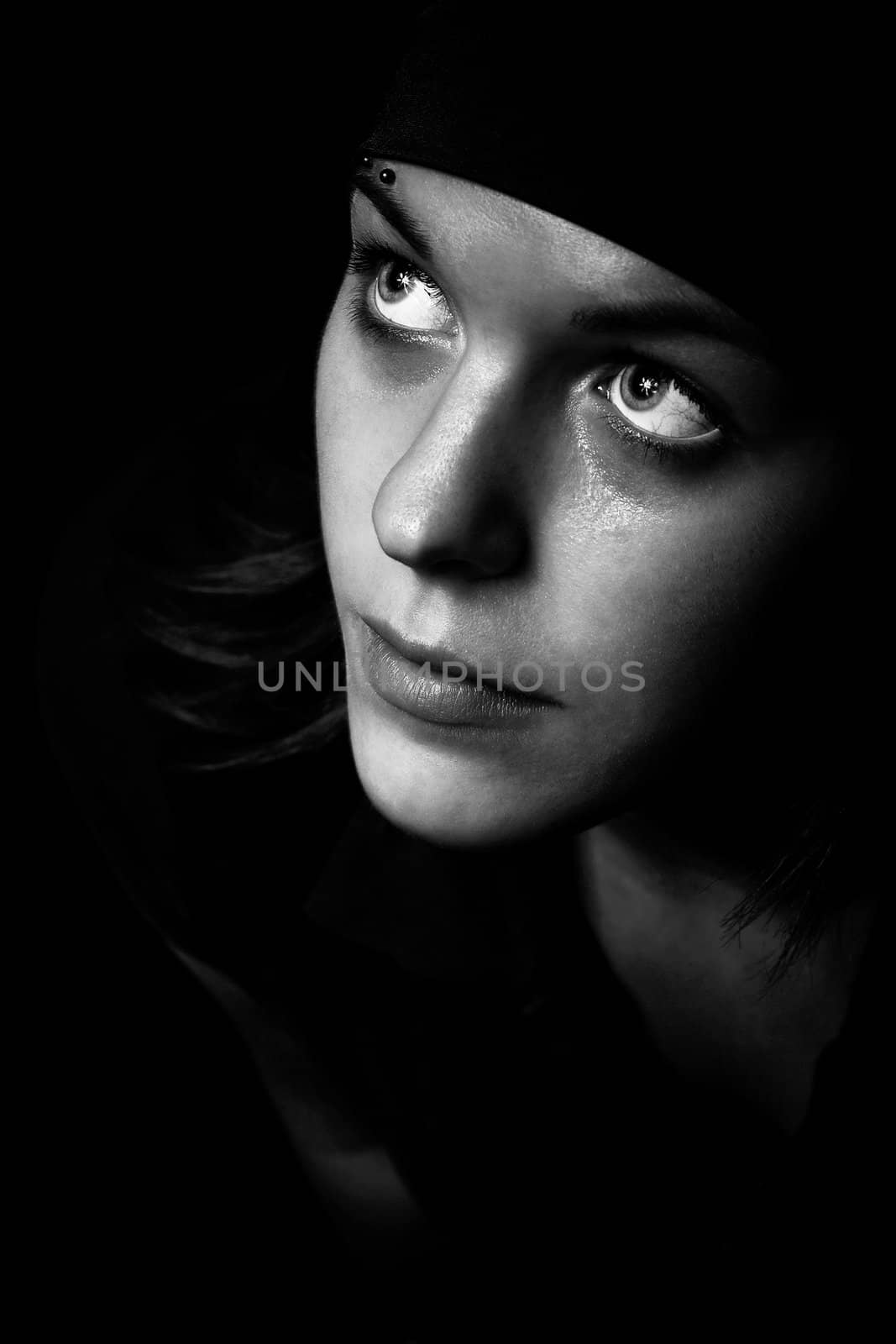 Black and white shot of a pretty girl looking up.

Studio shot.