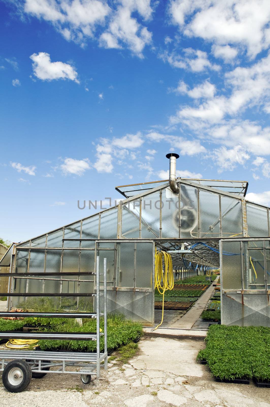 External view of a glasshouse against a sky with clouds