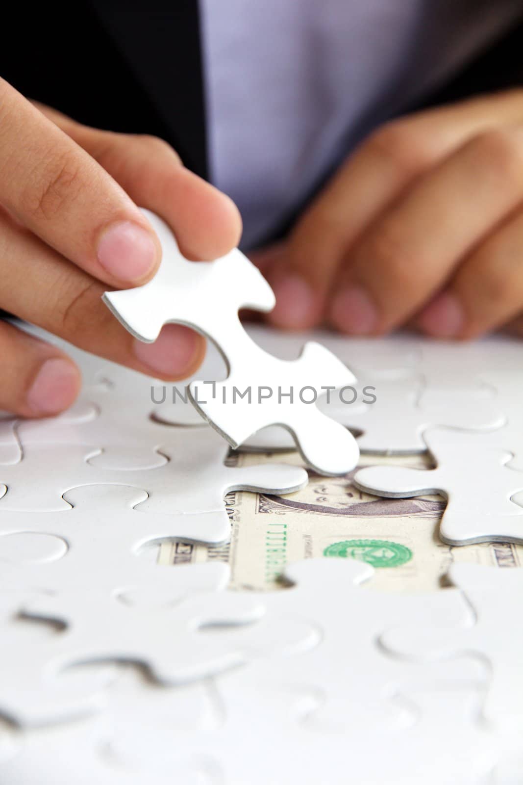 business man hand holding a puzzle piece, money concept