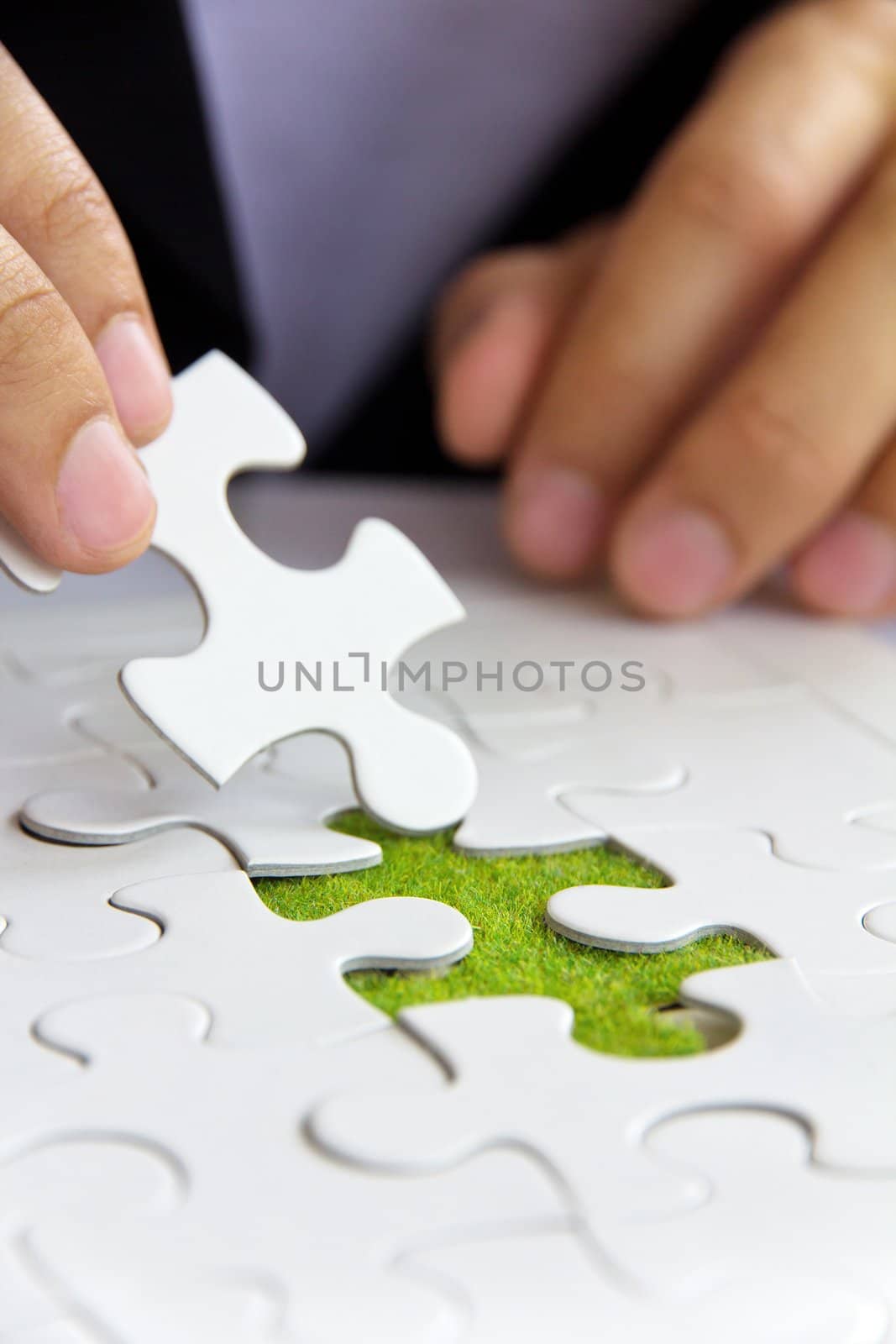 hand holding a puzzle piece, green space concept by ponsulak