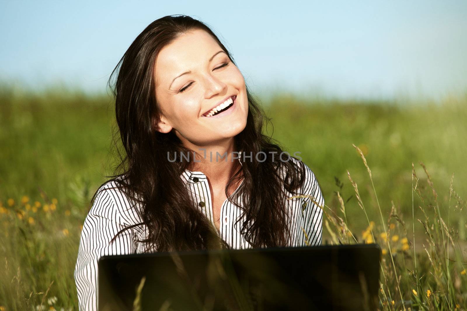 woman on green field work on laptop