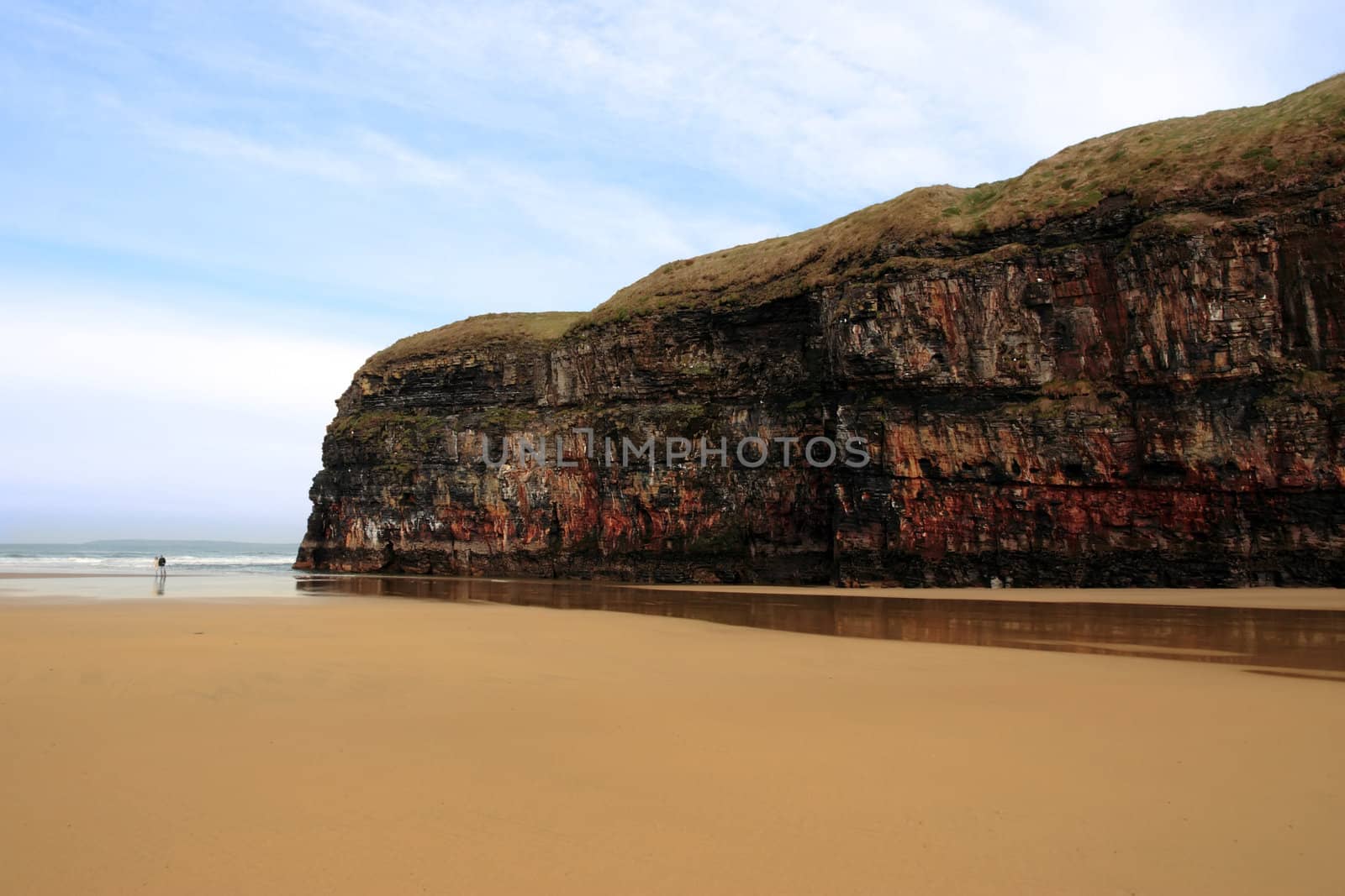 a view of a loving couple walking the beach cliffs in ballybunion co kerry ireland