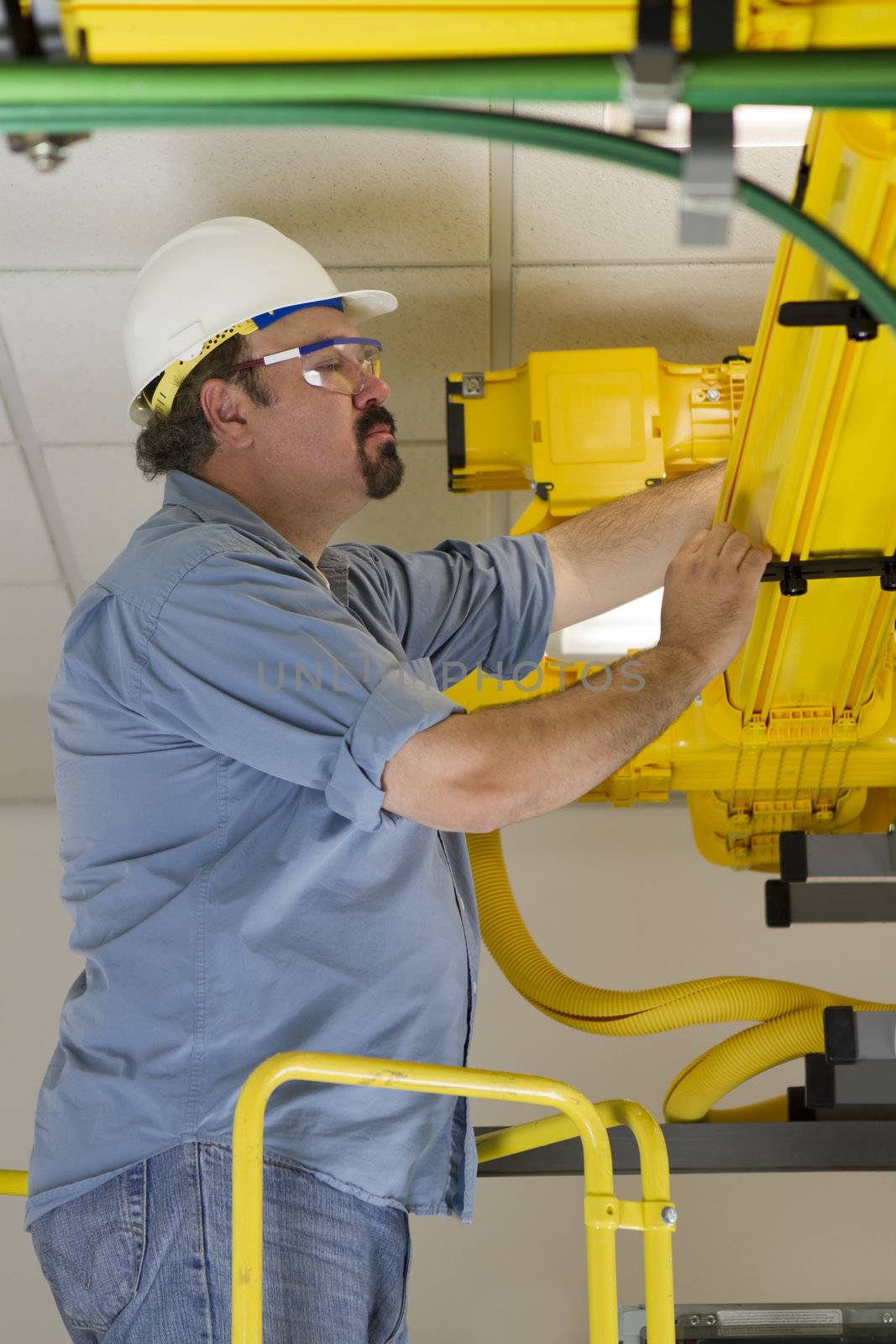 Telecom Switch Worker inspecting Fiberoptic Cables by coskun