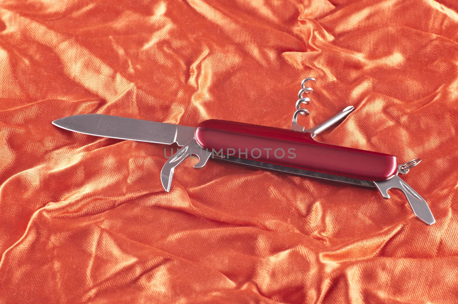 Pocket knife on beautiful red fabric