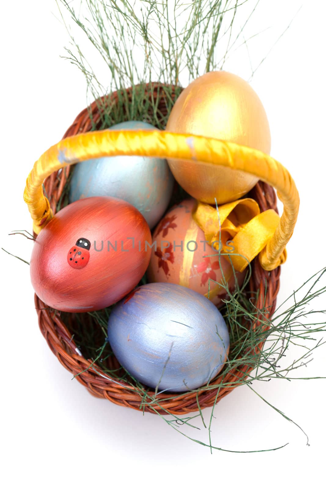 Colorful painted easter eggs in basket on white