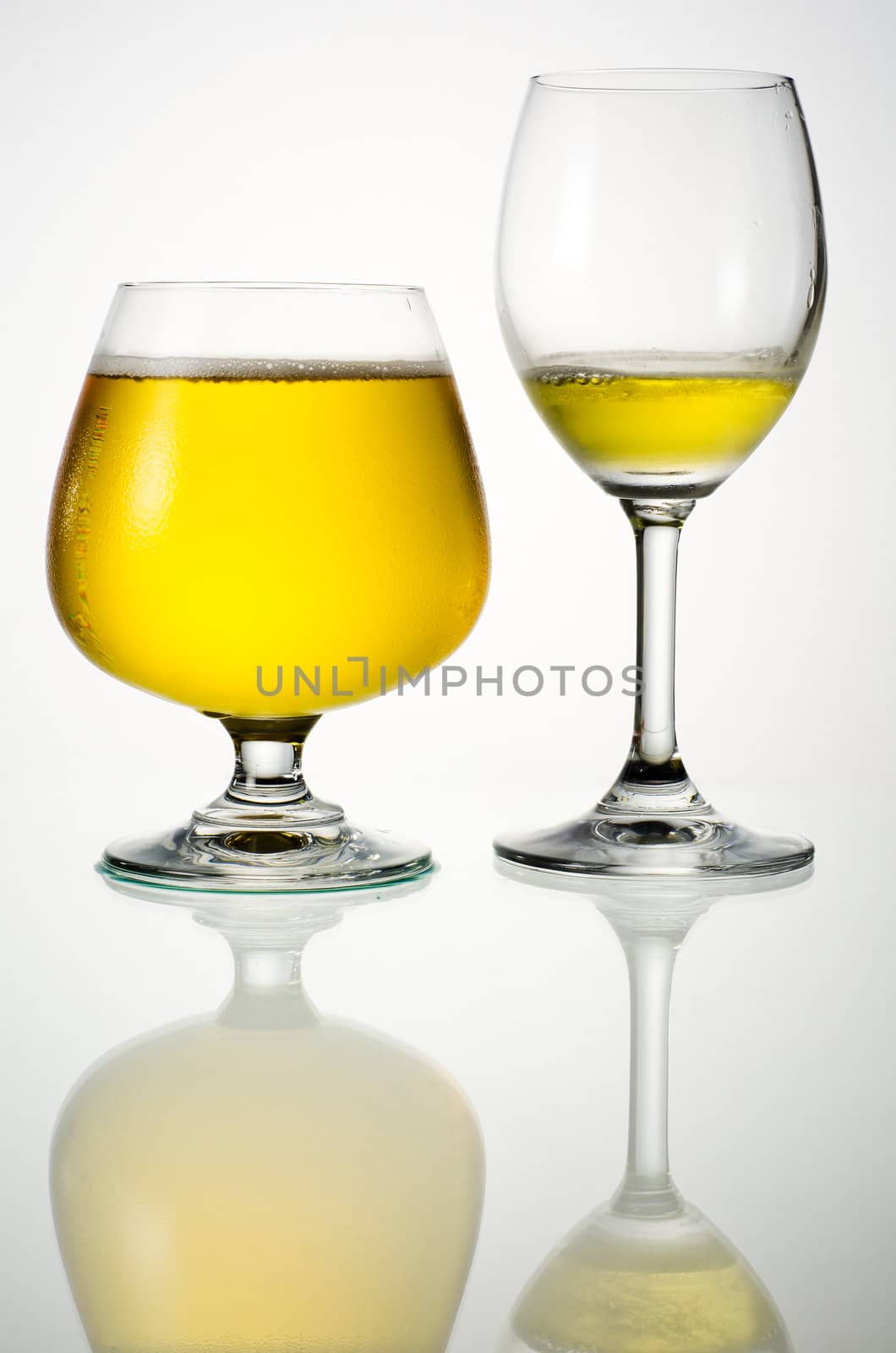 Beer in glasses with reflection on a white background