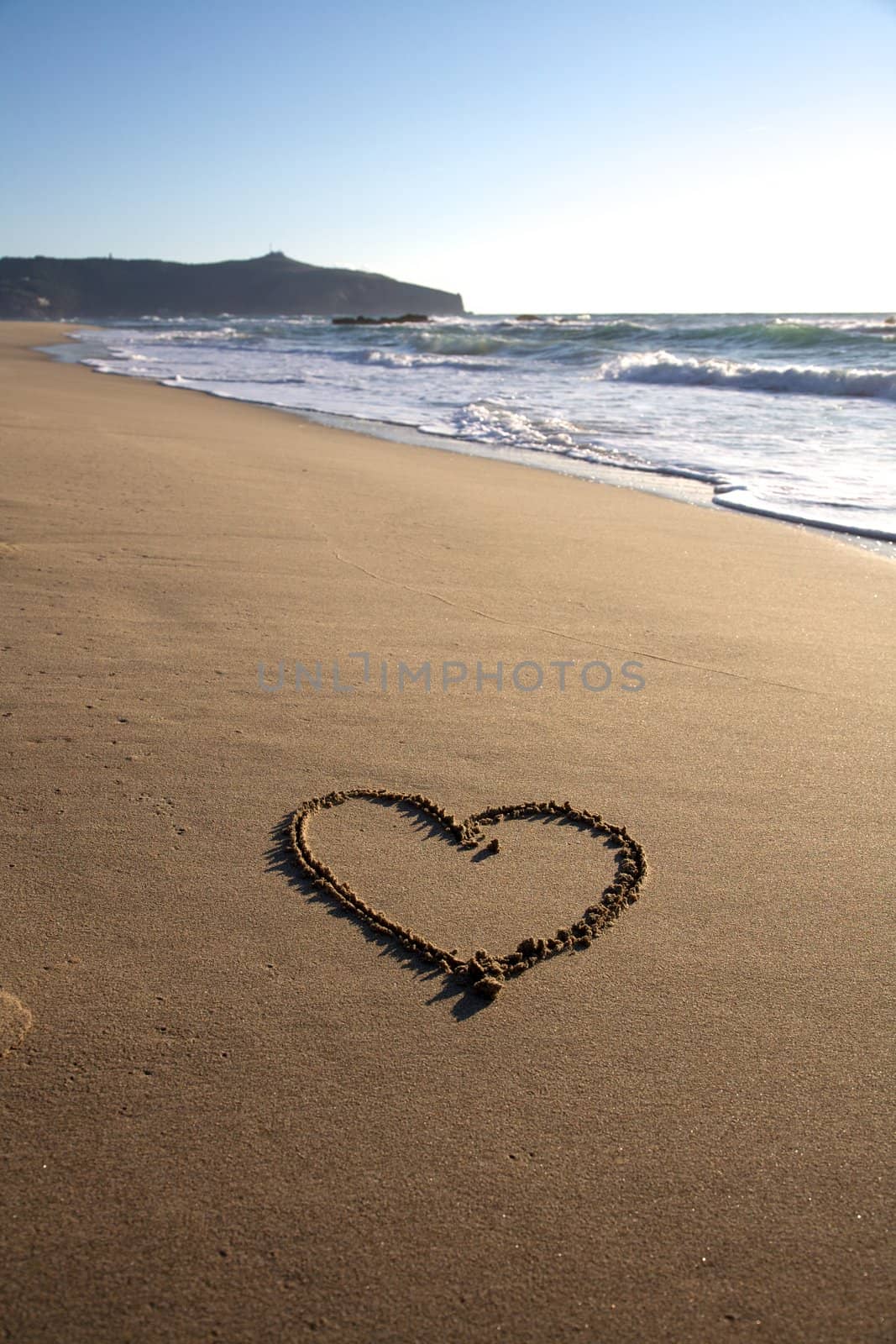 Valentine's Day heart on the beach in italy with nice waves