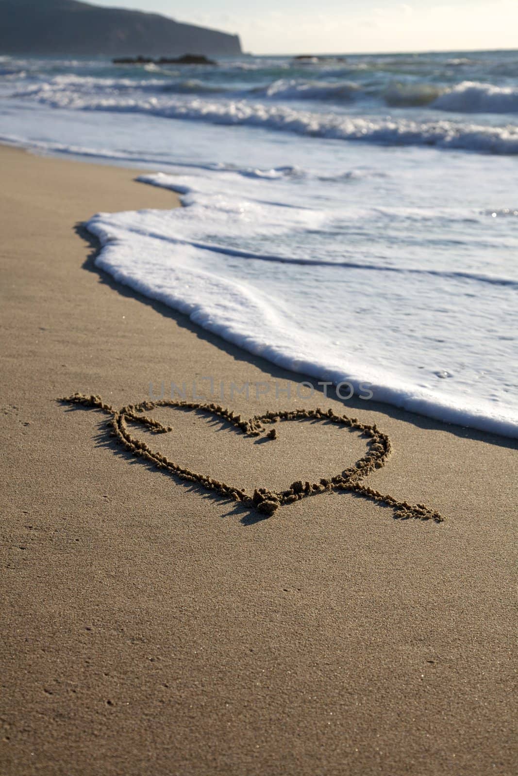 Valentine's Day heart with cross on the beach horizontal with sea going to canel it by fmarsicano