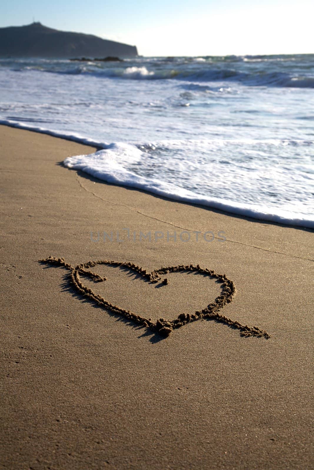 Valentine's Day heart with cross on the beach 