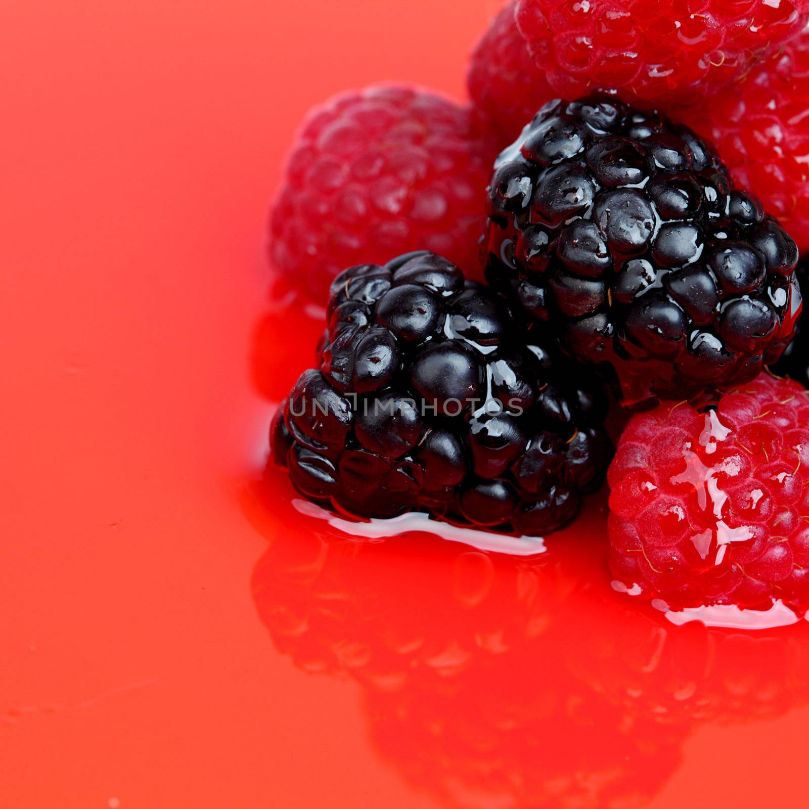 berry mixed pile in syrup isolated on white