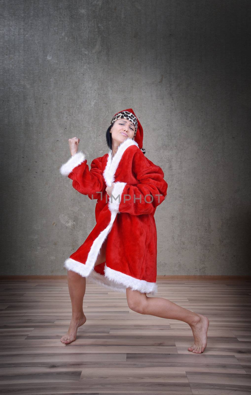 Happy dancing woman in the red costume of Santa Claus