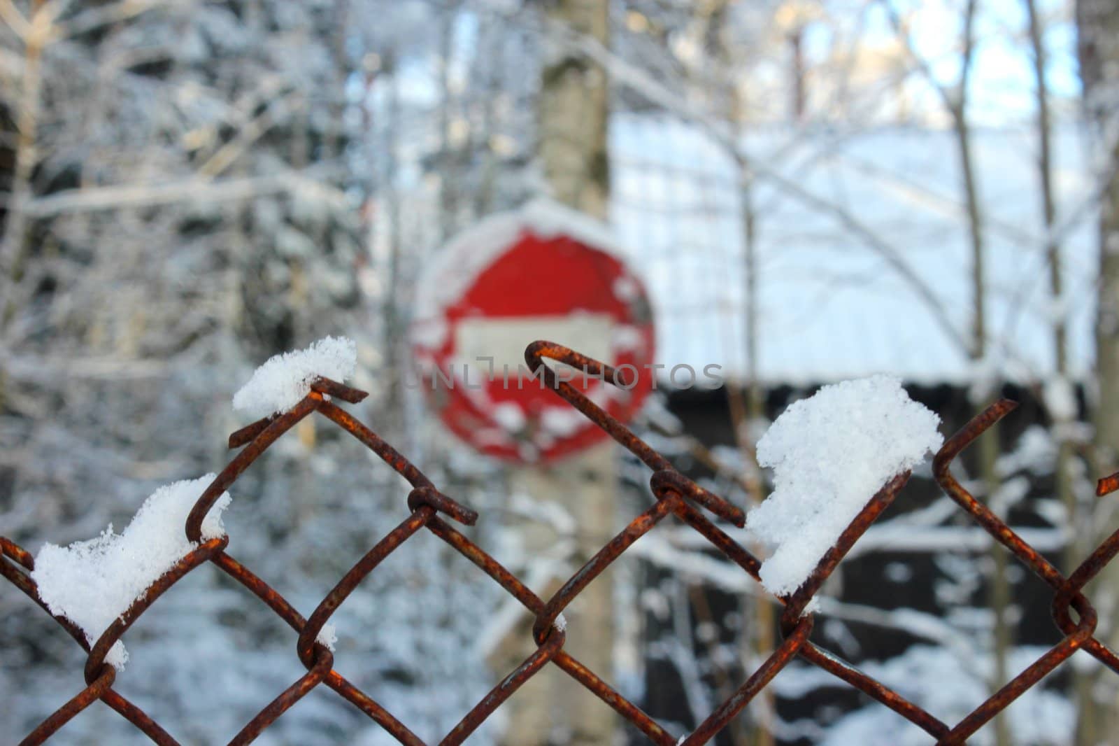 old road sign road up in the winter landscape looked through a rusty grate