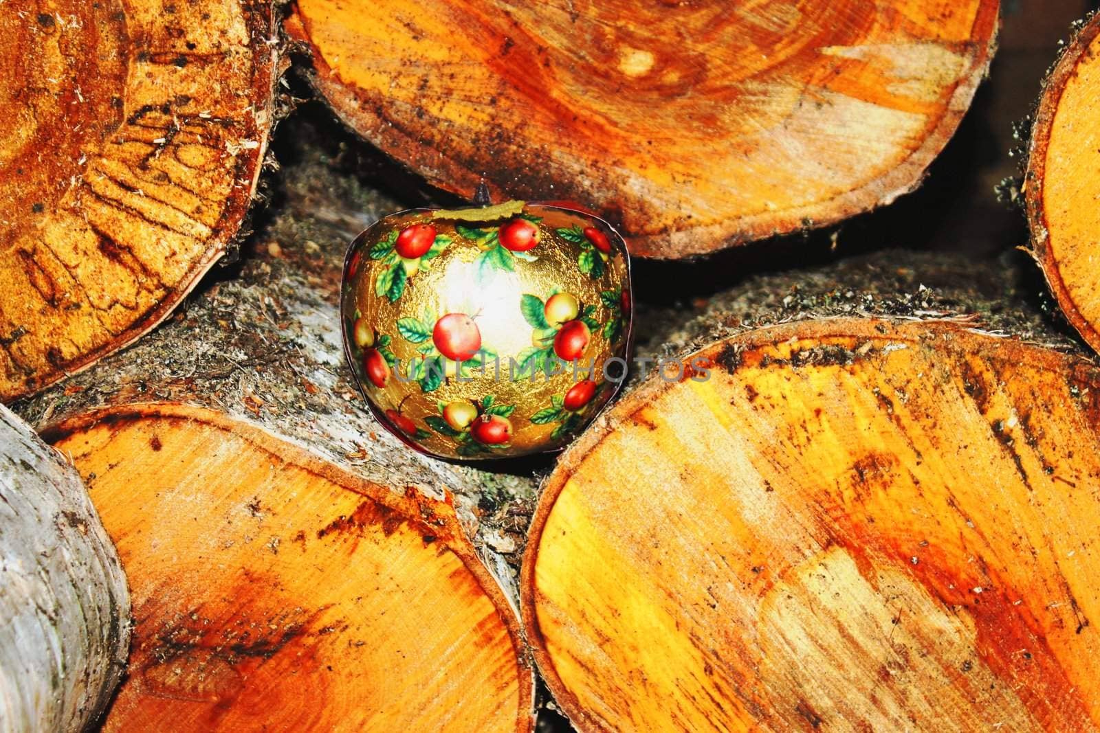 Christmas apple lying in a beautifully roled firewood