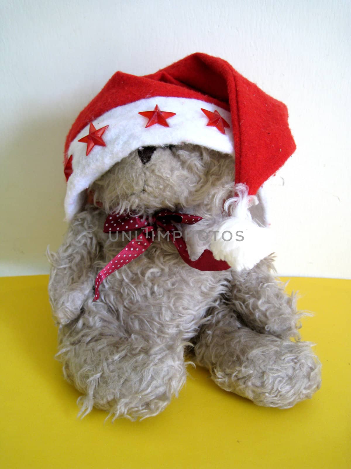 a Santa bear is sleeping, his hat cover his eyes.