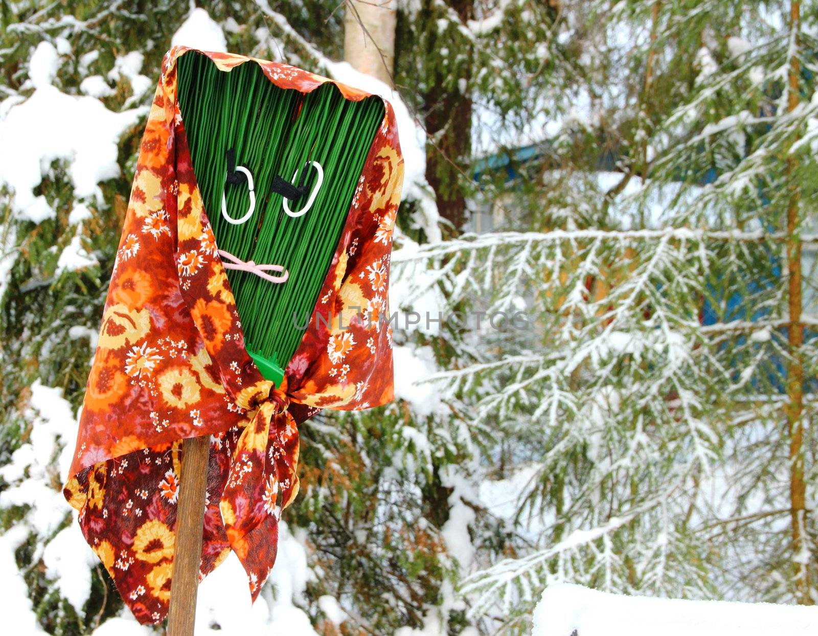 Funny broom with an ugly face in winter, snow landscape