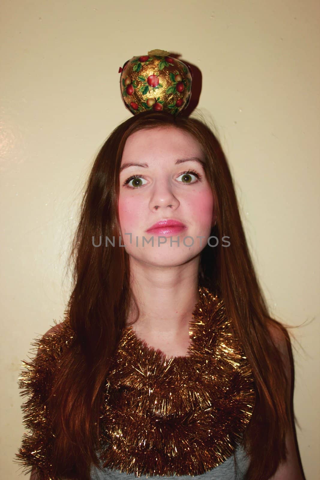 Cheerful girl with an apple on his head.She  looks up