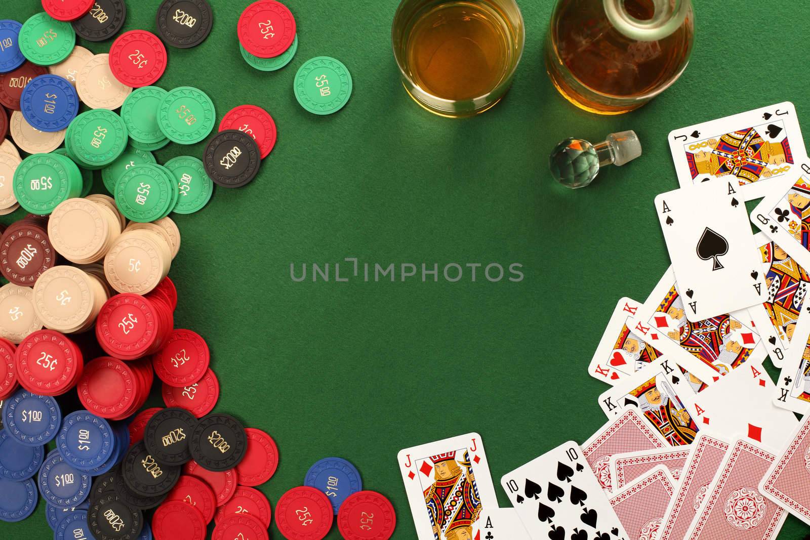 Photo of a poker table with gambling chips, cards and whisky.