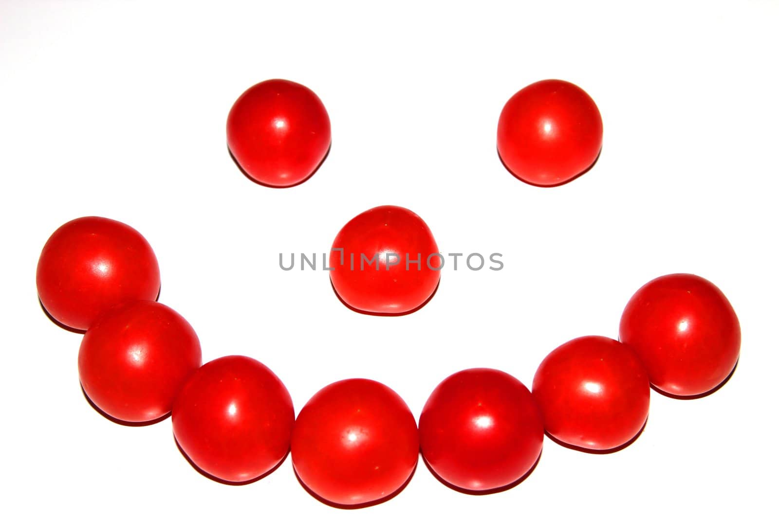 Smiling ugly face from little tomatoes isolated on white background