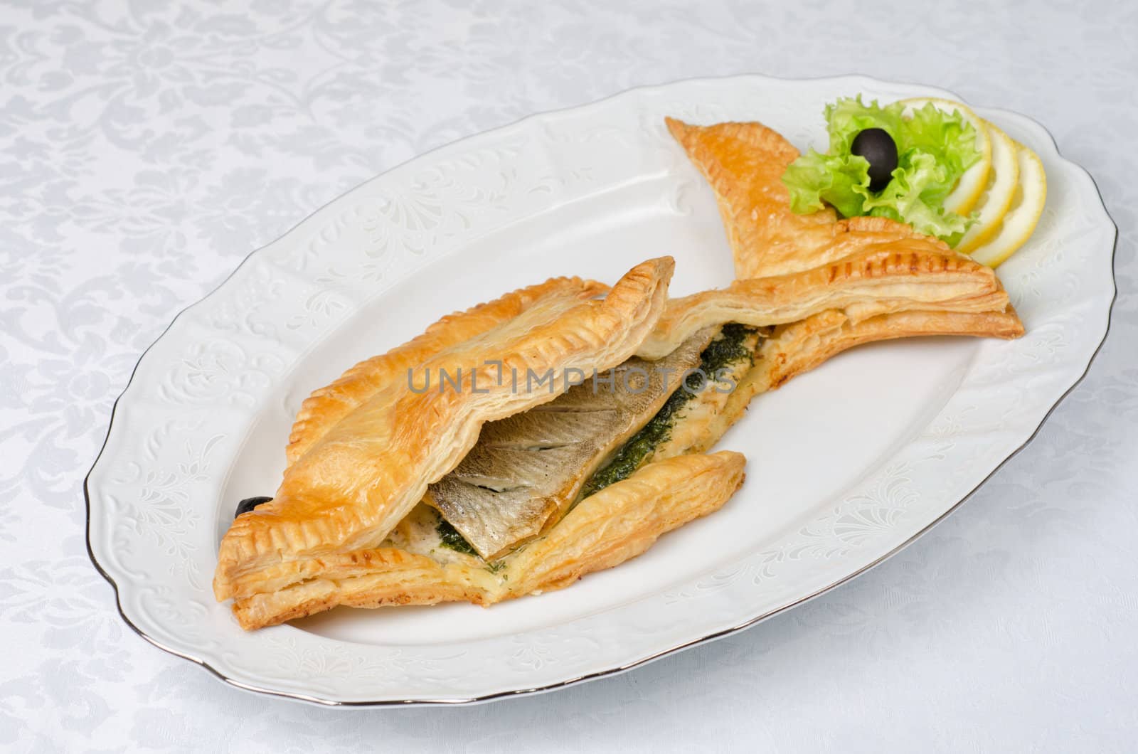 tasty dish of trout fish baked with greens at dough