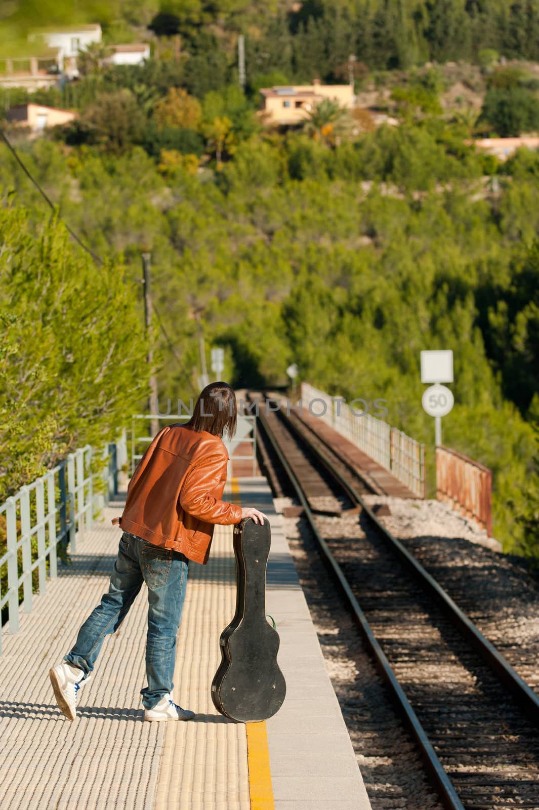 Commuter with a guitar waiting for the train