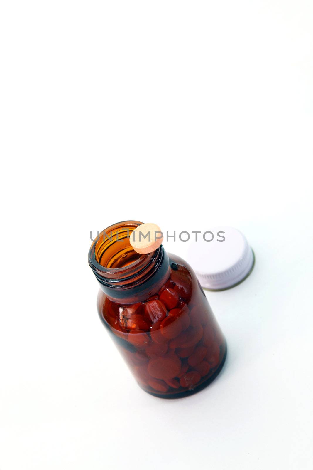 perspective of pill on pill bottle isolated on white