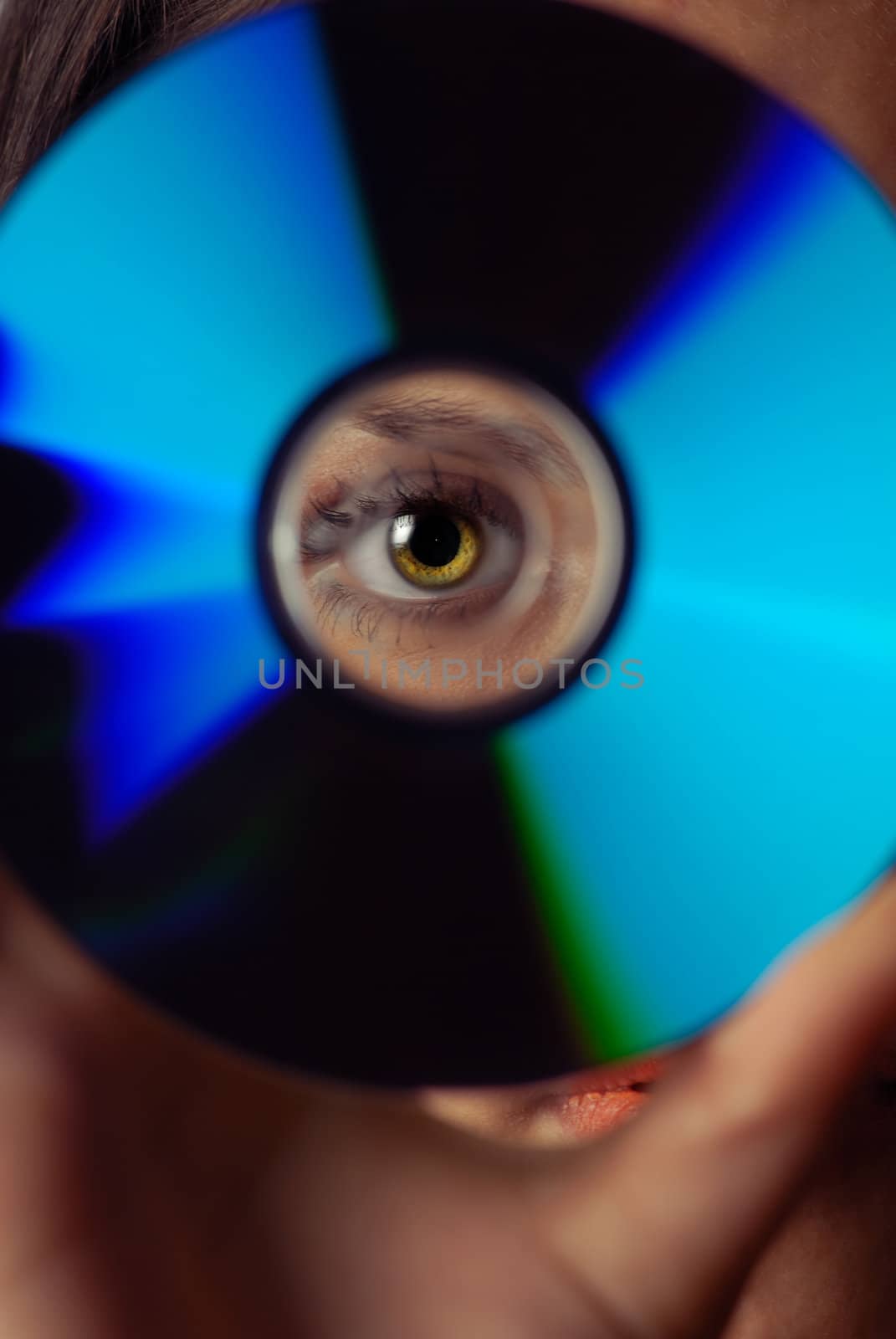 Woman peeping through compact disk